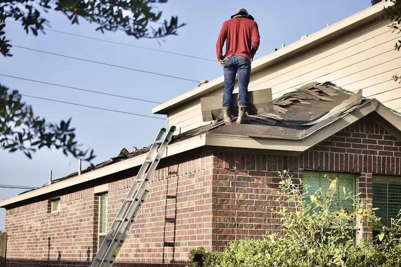 Professional roofer working on a residential roof in Stapleton